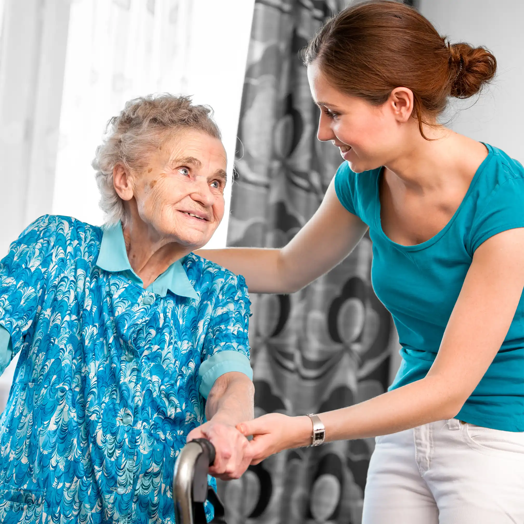 Carer helping elderly lady walk