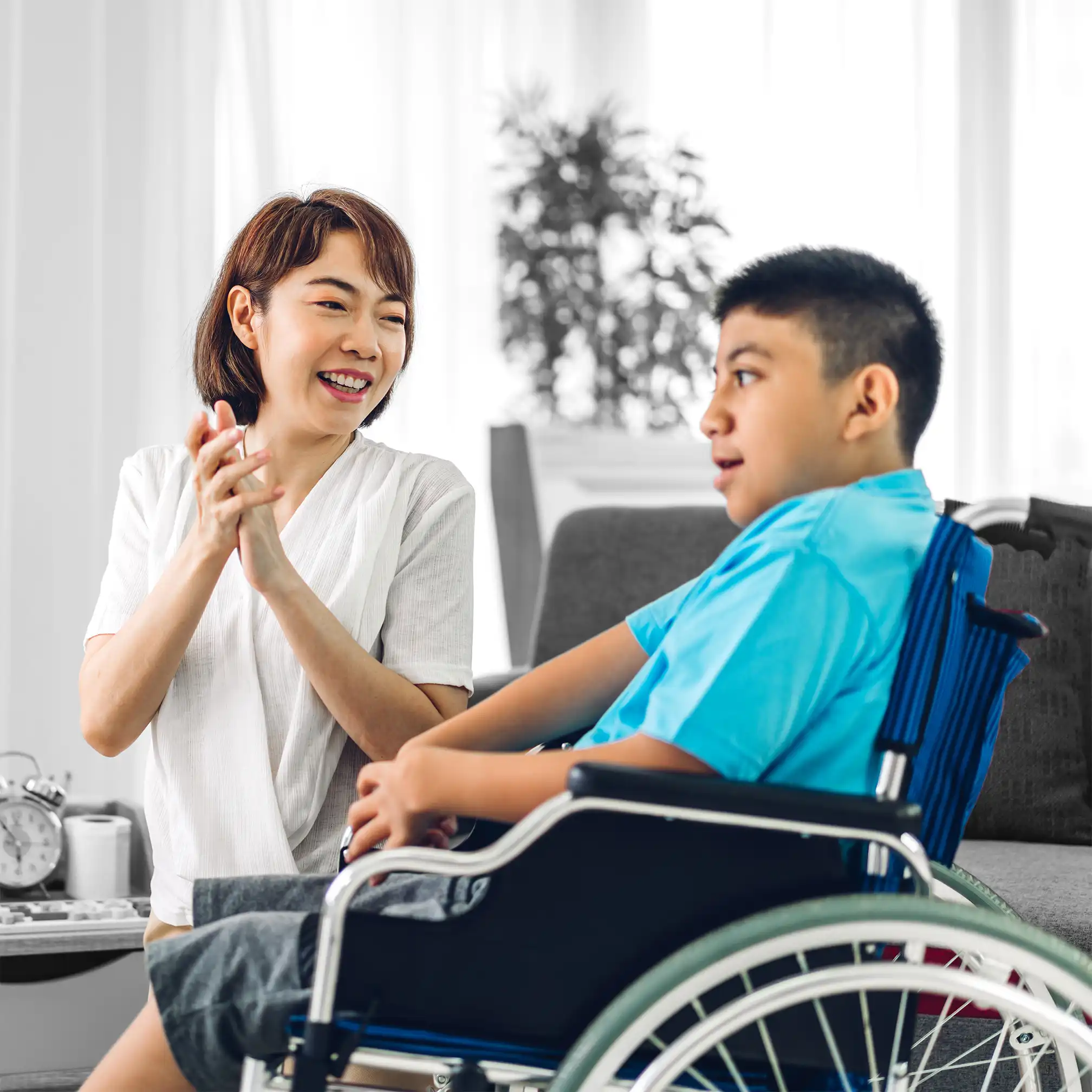 Nurse clapping with sick boy in wheelchair